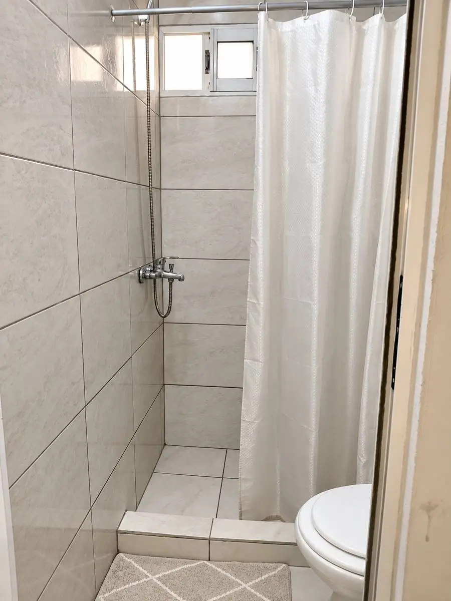 Baño privado con ducha y cortina blanca