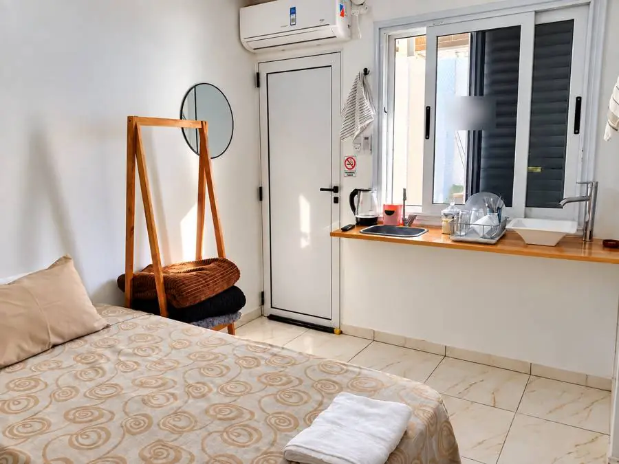 Habitación con cama, kitchenette junto a la ventana y aire acondicionado