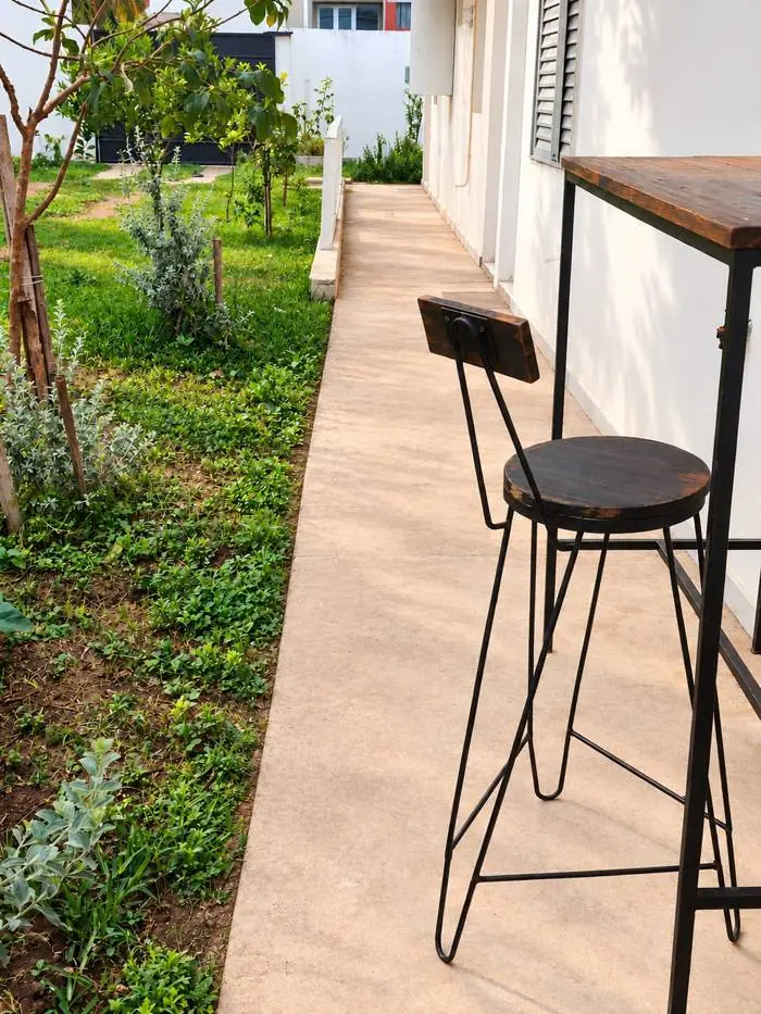 Banqueta y mesa alta sobre la vereda del jardín