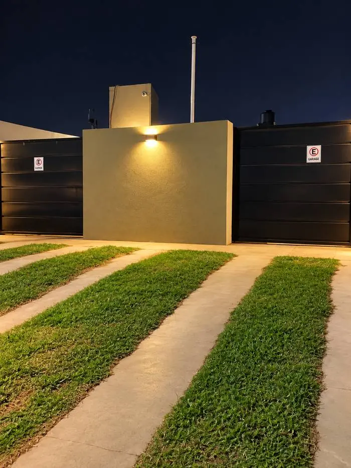 Entrada de las cocheras de noche, con portones y carteles de garage